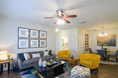 a living room with a ceiling fan and a couch at The Madison Apartment Homes in Tyler, TX  